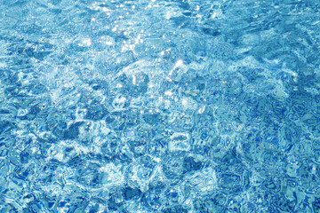 Water ripples on blue tiled swimming pool background. View from above. vacation and summer concept. 