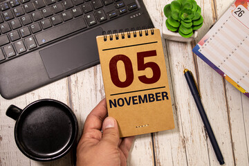 Wooden calendar on dark background, date 5 November