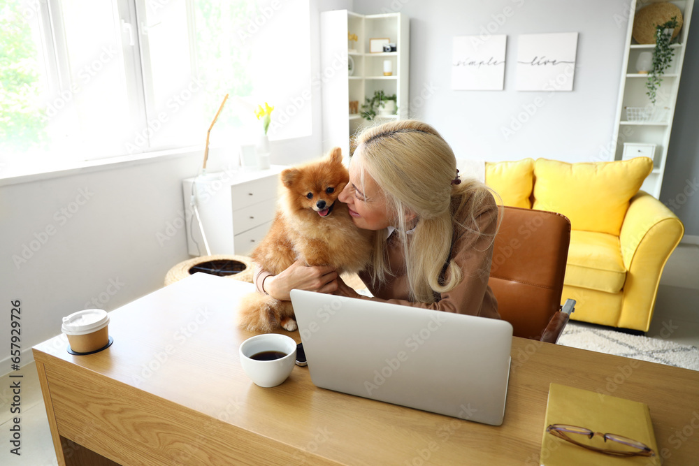 Sticker mature woman with pomeranian dog at table in office