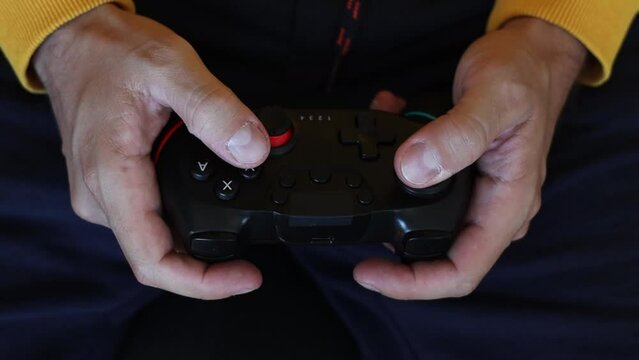 Man playing video game on gamepad.