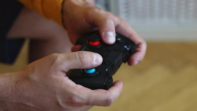 Man playing on a console with a gamepad.