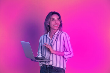 Beautiful woman with laptop in neon lights