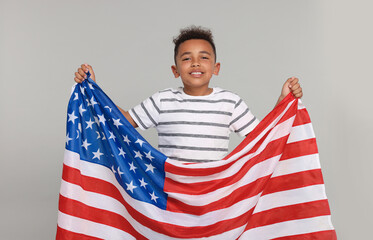 4th of July - Independence Day of USA. Happy boy with American flag on light grey background