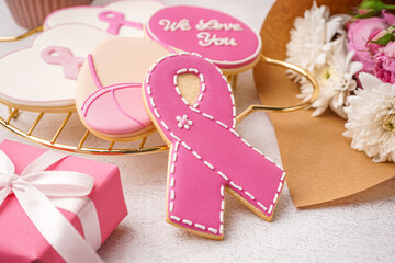 Pink cookie in shape of ribbon on white grunge background, closeup. Breast cancer awareness concept