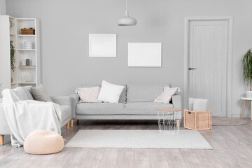 Interior of light living room with grey sofas
