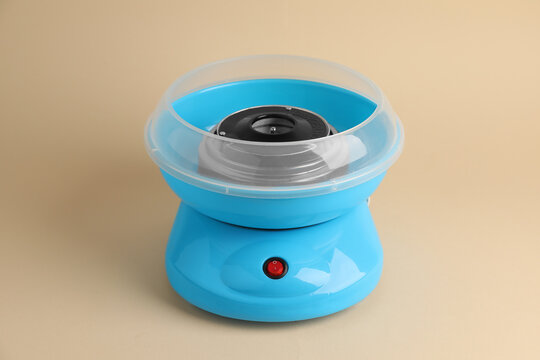 Portable candy cotton machine on beige background