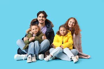 Happy family in puffer jackets on blue background