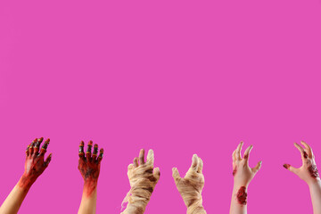 Zombie and mummy hands on pink background. Halloween celebration
