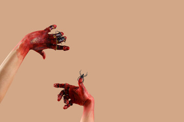 Bloodstained zombie hands with spiders on beige background. Halloween celebration