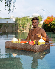 man having breakfast in the pool
