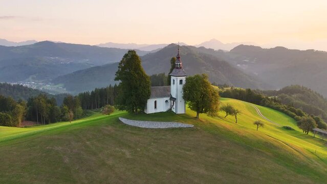 Aerial view of St. Thomas church (Cerkev Sveti Tomaz) on top of a hill, sunrise, Skofja Loka, Slovenia