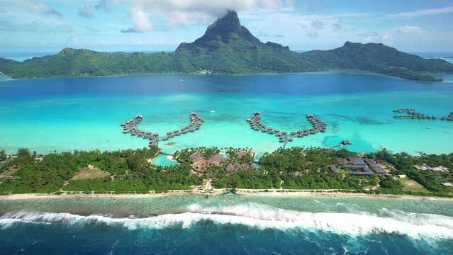 Aerial Bora Bora drone view of overwater bungalow villas in lagoon, Tahiti 4k, French Polynesia. Luxury honeymoon vacation, romantic getaway, exotic resort destination. 