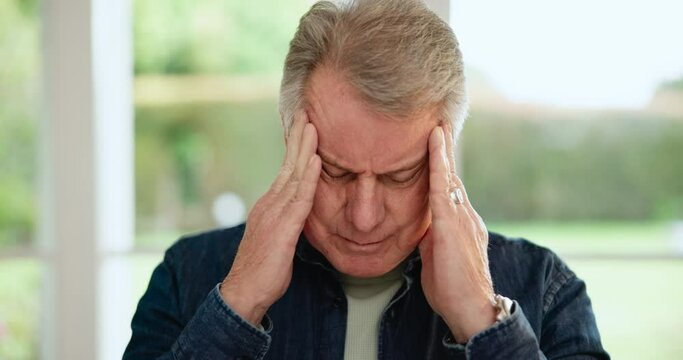 Headache, senior man and stress in home from retirement, debt or sick and anxiety. Migraine, dementia worry and tired elderly male person in a house with mental health, head massage and pain