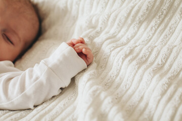 A little newborn baby sleeping, close up on his hand