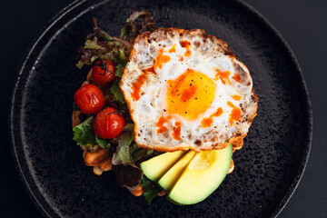 Breakfast waffles, fried eggs, avocado and salad