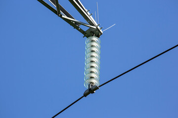 High voltage tower with electrical voltage wires isolates close-up against the background of...