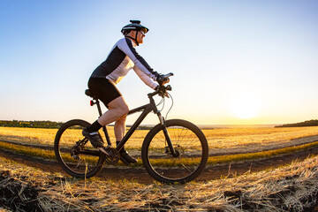 man cyclist rides a bike on a road in nature. sports, cycling and health hobbies