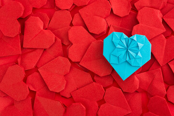 Blue origami heart on red origami hearts