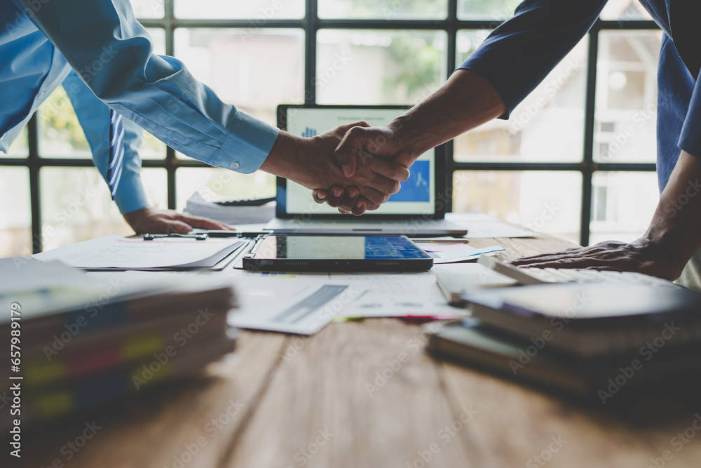 Wall mural Young businessman and financial representative shaking hands after a budget deal for business expansion and investment in a village construction project real estate financial concept.