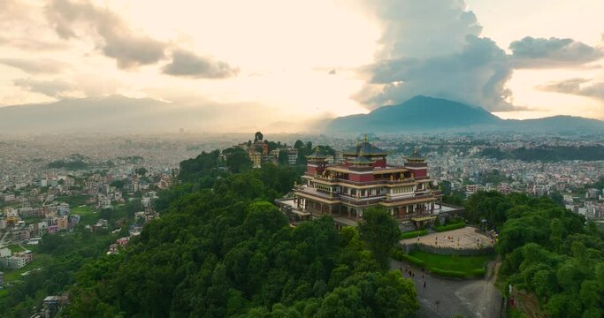 Golden Hour Drone flies Kapan Buddhist Monastery Kathmandu Nepal. Reveals Urban city, airport and culture epitome. Clouds, hills, landscapes, greenery, sunrays, birds with serene natural resources. 4K