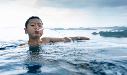 Boy swimming and spitting water from mouth