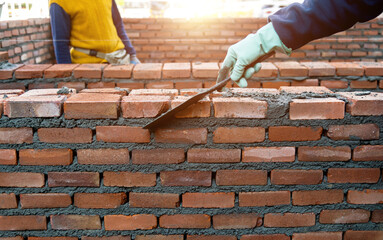 Close up of bricklayers building walls