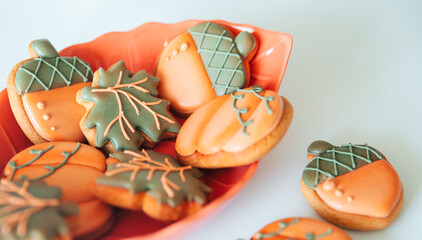 Gingerbread cookies in the shape of a pumpkin, acorn and maple leaf with multi-colored glaze in an...