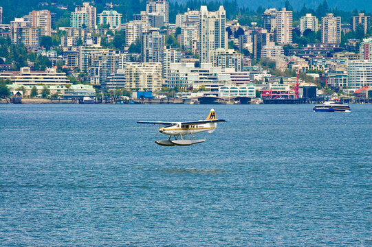 Seaplane arriving at Vancouver Bay in British Columbia, Canada. with north vancouver in the background and close to canada place and stanley park