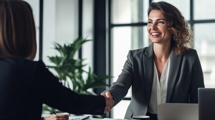 Happy business woman manager handshaking client for successful deal at meeting table in office. - obrazy, fototapety, plakaty