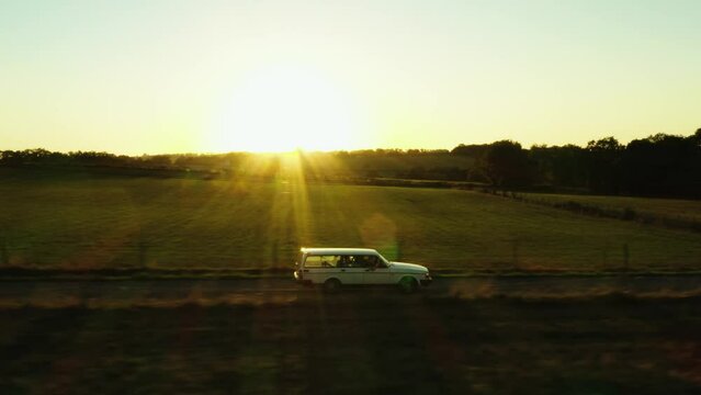 Cinematic aerial shot of Volvo driving through France landscape, trees, roads and villages.