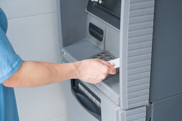 Close-up of woman's hands using ATM with contactless nfs access. 