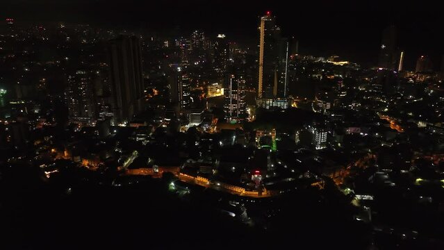 Aerial view of urban borough in night city. Backwards reveal of colour top of famous Lotus Tower. Colombo, Sri Lanka