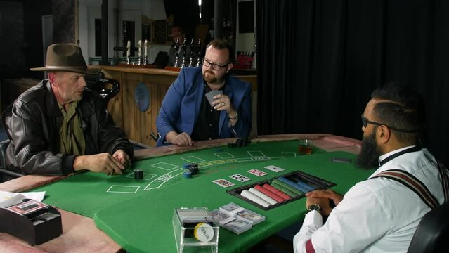 Two men playing poker in a casino bar on a black jack table with a croupier dealer