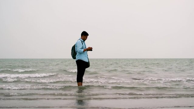 Photographer taking picture at sea shore in Kuakata, Bangladesh. Tourists in bay of bengal sea