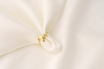 Golden ring on white silk cloth background