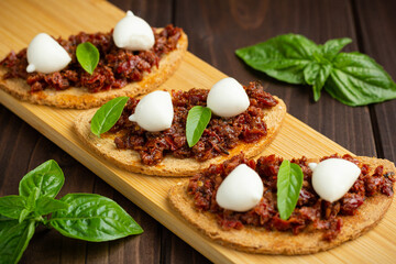 Bruschetta with dried tomatoes, mozzarella, garlic and olive oil. Traditional Italian cuisine...