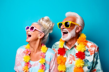 Man and woman wearing sunglasses and leis with flowers. - obrazy, fototapety, plakaty