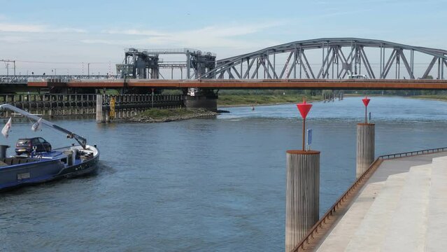 Cargo ship sails under the bridge at the IJssel river near Zutphen in the Netherlands