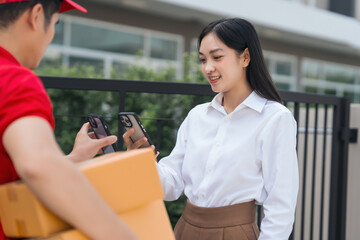 Fototapeta premium Asian people received product box from male delivery service person, modern e-commerce, home deliveries, convenient shopping experience, trustworthy doorstep service captured in moment.