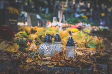 All Saints Day in cemetery in nostalgic autumnal time, autumnal colors, orange and yellow leaves - 658066132