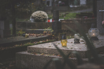 All Saints Day in cemetery in nostalgic autumnal time, sadness and loneliness