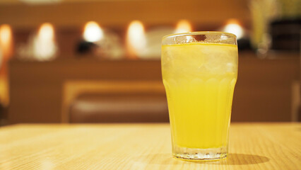 a glass of ice tea on vintage wooden table on the background of Blurred interior of luxury restaurant panoramic background.