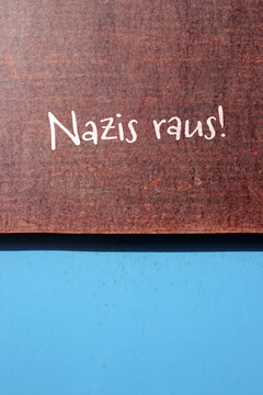nazis raus - auf braunem schild an blauer wand