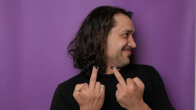 A funny, handsome guy shows indecent hand gestures. 