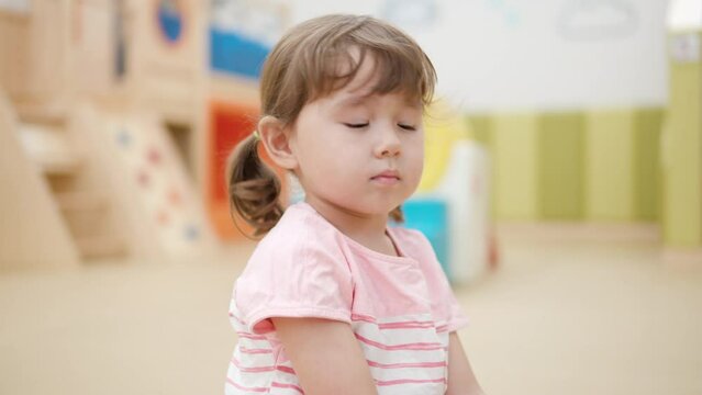 Bored 3-year-old Little Girl Toddler in Playroom Strick with Wooden Sticks on Toy Xylophone in slow motion - face close-up