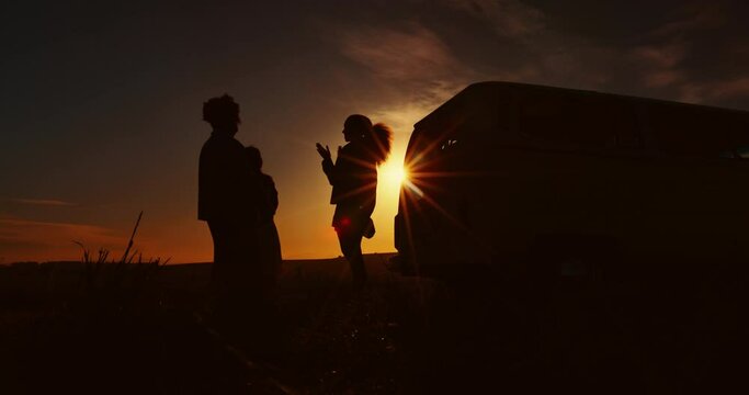 Hive five, silhouette and group travel with van in at sunset, night or dark together on vacation packing luggage or bags. Friends, love and people greeting for success on a trip, holiday and camping