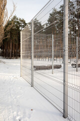 sports ground in winter, fenced with a metal mesh