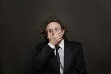 Fototapeta premium Shocked businessman on black background, studio portrait