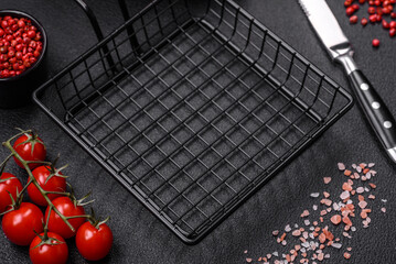 A black mesh or basket for deep-frying and cooking potatoes in boiling oil