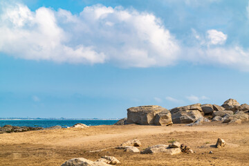 Fototapeta na wymiar Large sandy beach with stone boulders